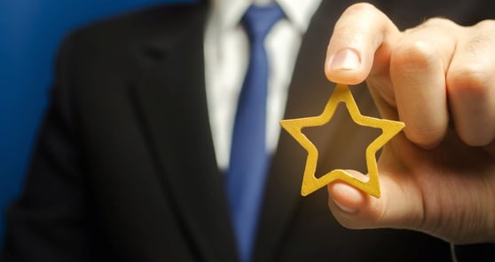 Man holds a golden star in his hand.
