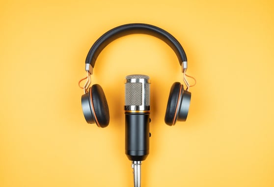 Headphones and recording microphone on orange background