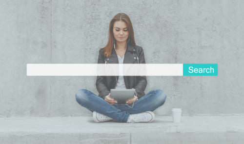 Woman sitting cross legged on the floor with a tablet in her hand and a search bar super-imposed over her image.